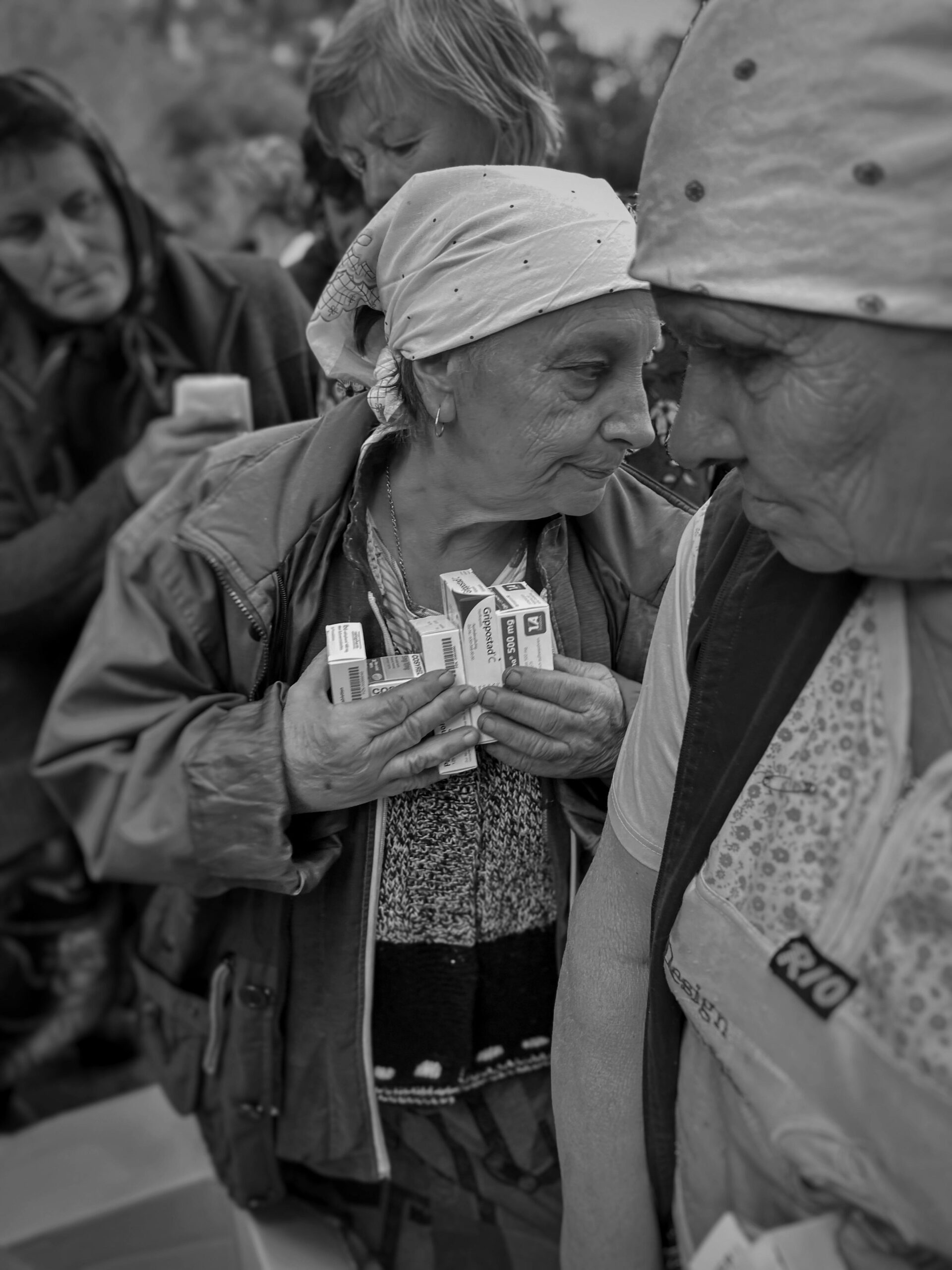 Elderly women receiving medical aid in Ukraine, highlighting humanitarian efforts.